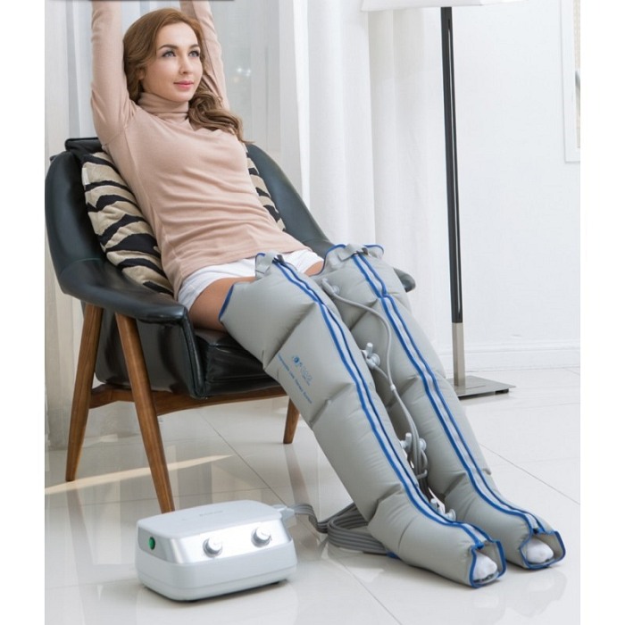 Siedząca osoba z mankietami na nogach oraz aparat